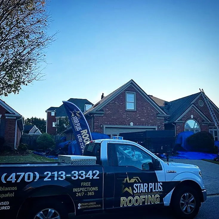 Star Plus Roofing truck parked in front of a brick home during a roof replacement