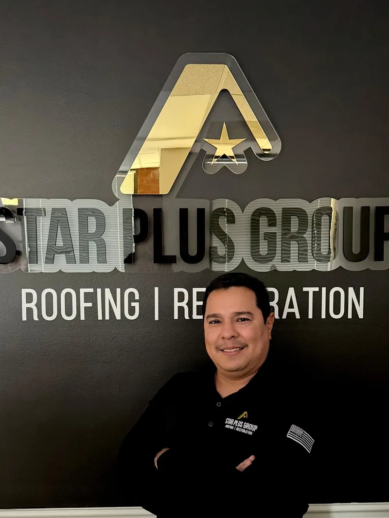 Star Plus Group team member in front of the company sign