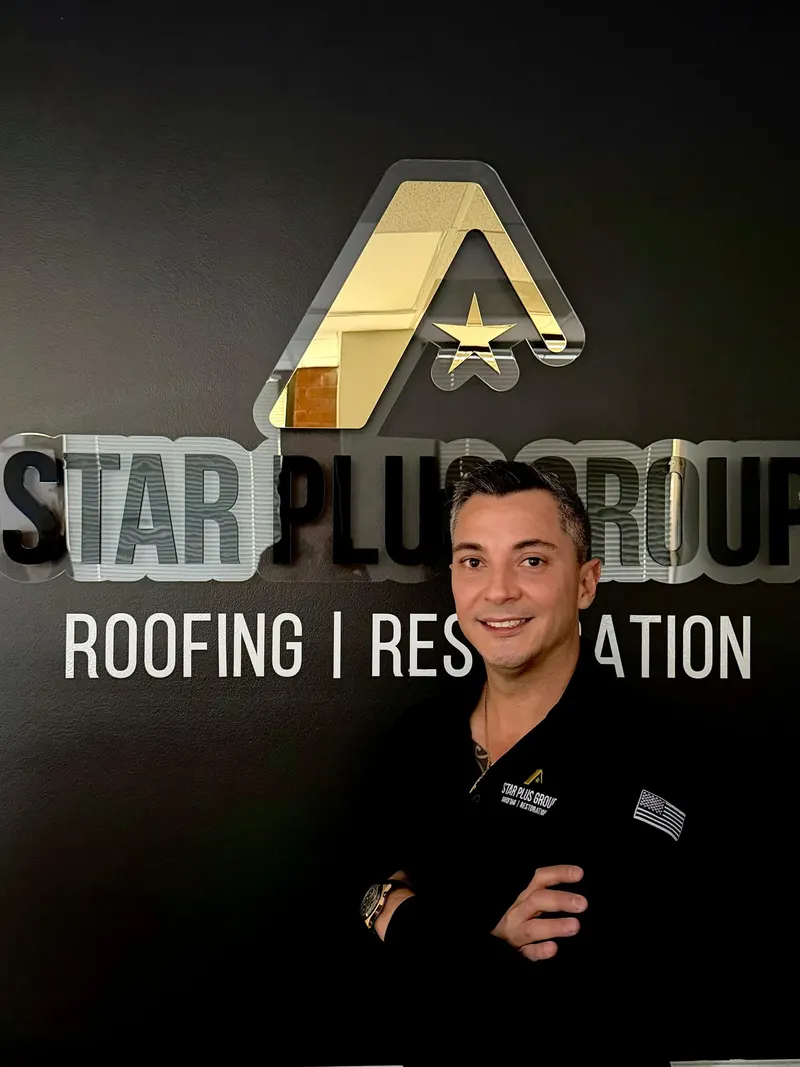 Star Plus Group team member in front of the company sign